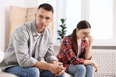 Photo of Offended couple ignoring each other at home