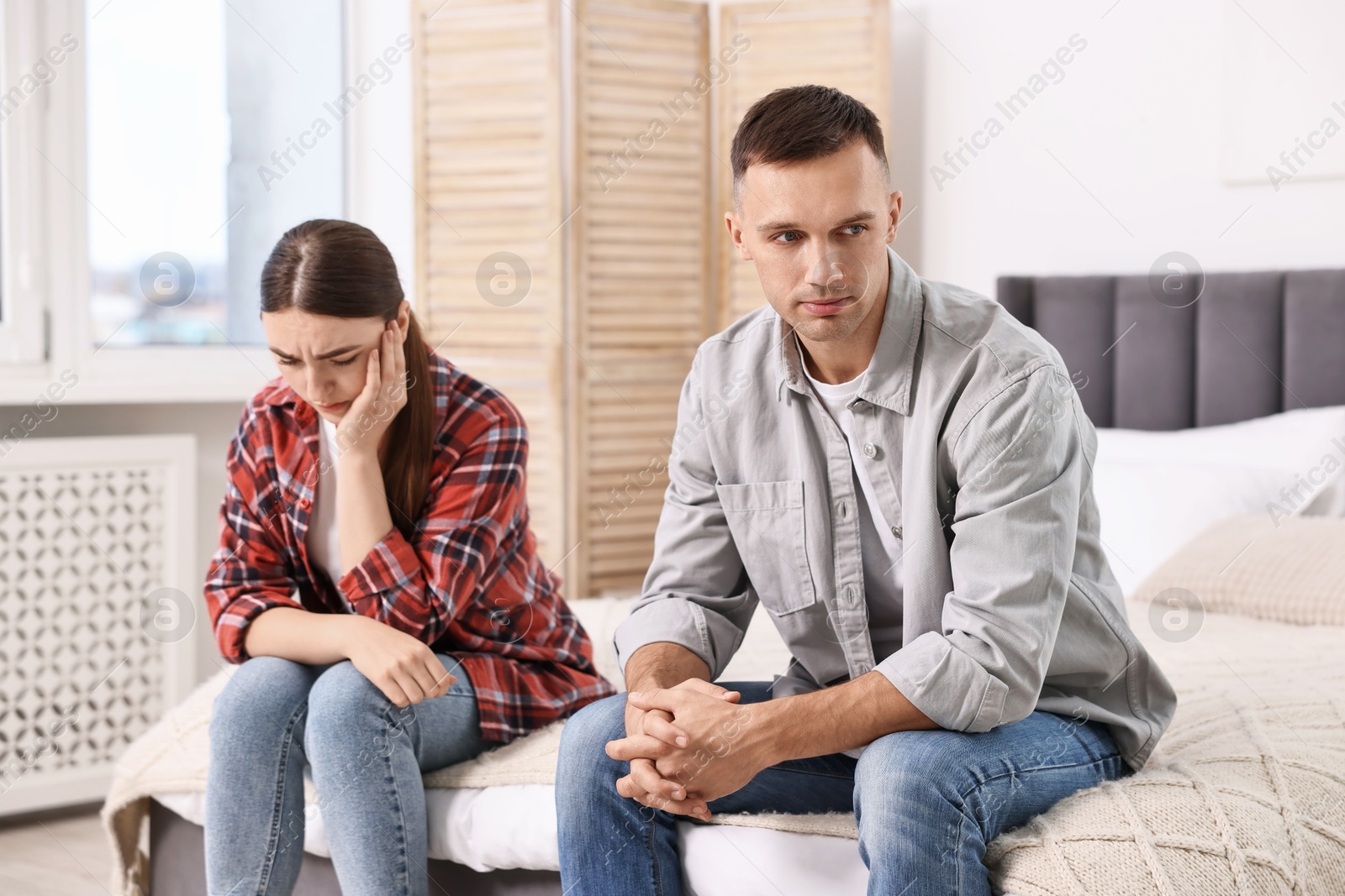 Photo of Offended couple ignoring each other at home