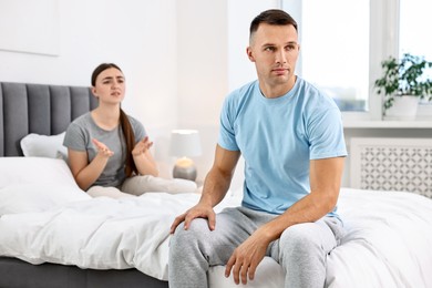 Photo of Wife apologizing her husband while he ignoring her in bedroom, selective focus