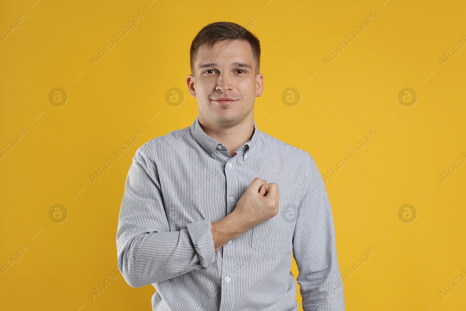 Photo of Man making promise on orange background. Oath gesture