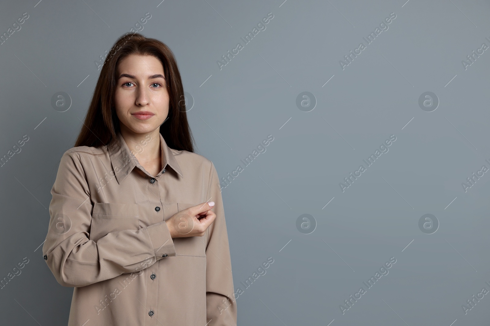 Photo of Woman making promise on grey background, space for text. Oath gesture