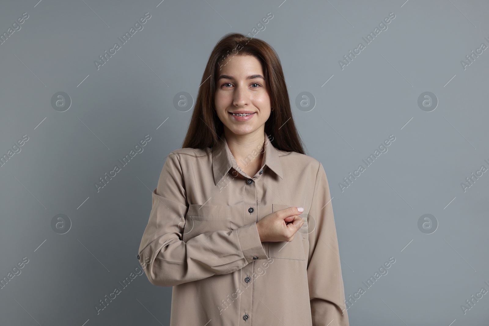 Photo of Woman making promise on grey background. Oath gesture