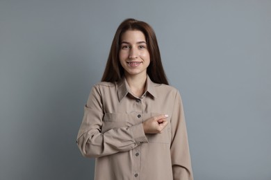 Photo of Woman making promise on grey background. Oath gesture