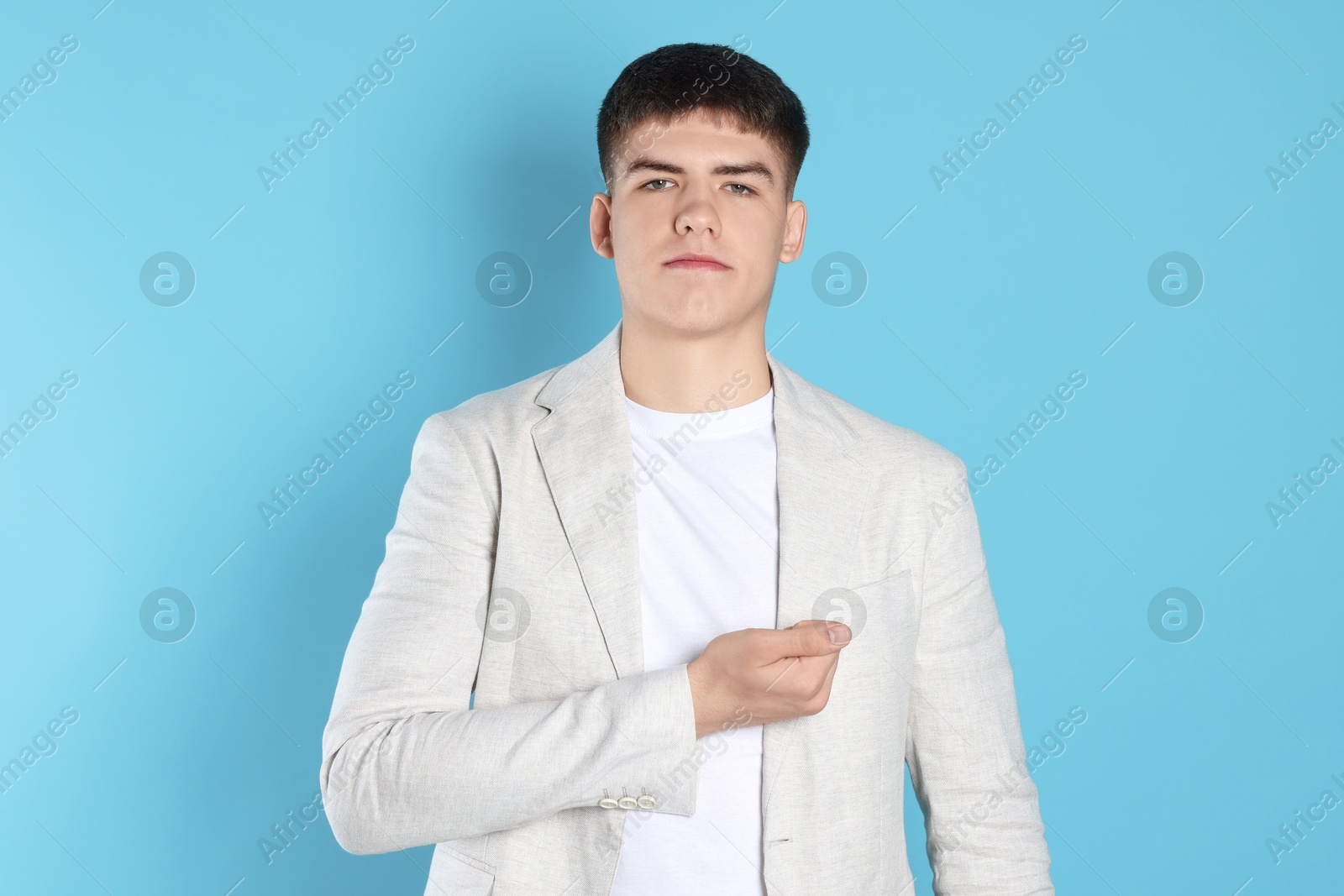 Photo of Man making promise on light blue background. Oath gesture