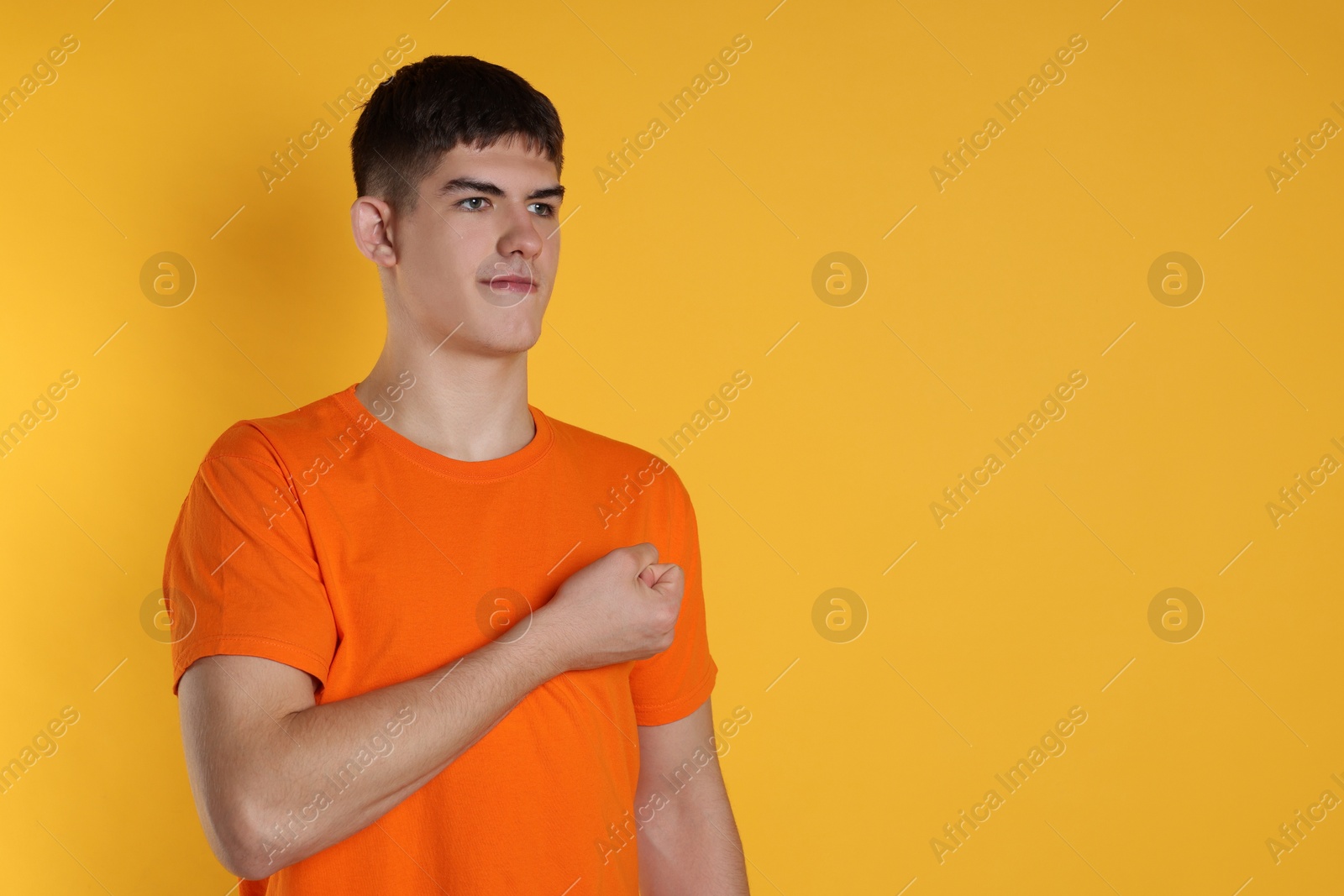 Photo of Man showing oath gesture on orange background. Space for text