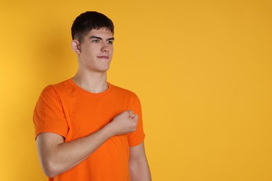 Photo of Man showing oath gesture on orange background. Space for text