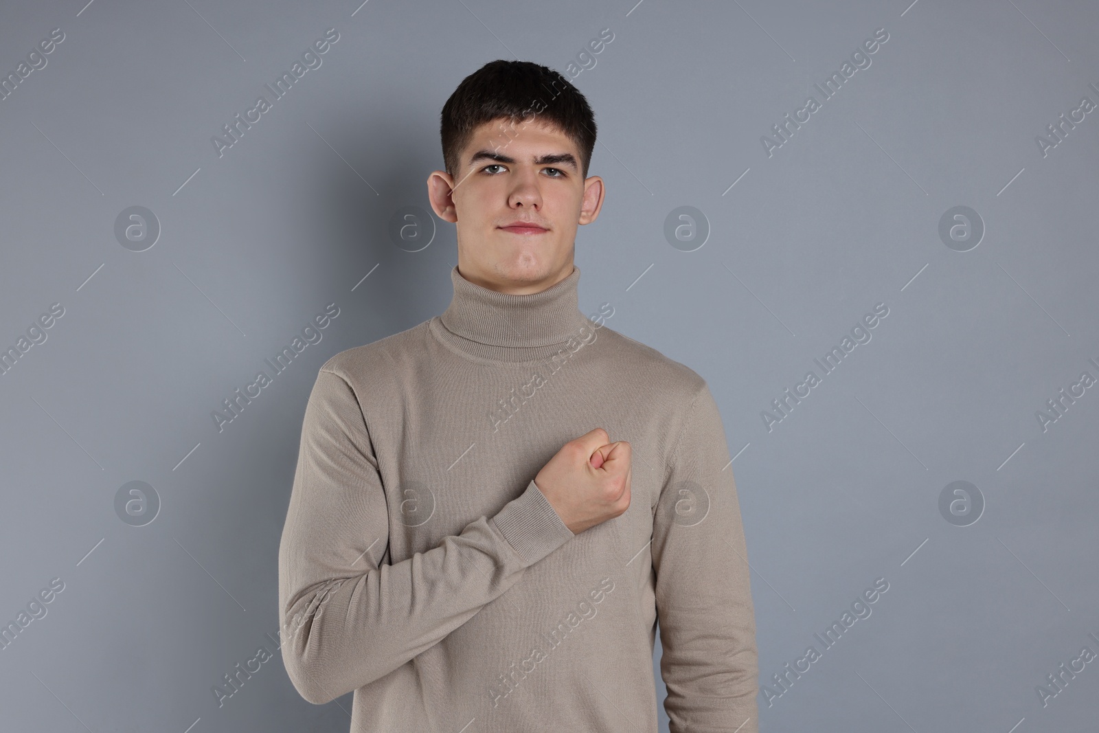 Photo of Man showing oath gesture on grey background