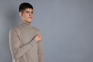 Photo of Man showing oath gesture on grey background. Space for text