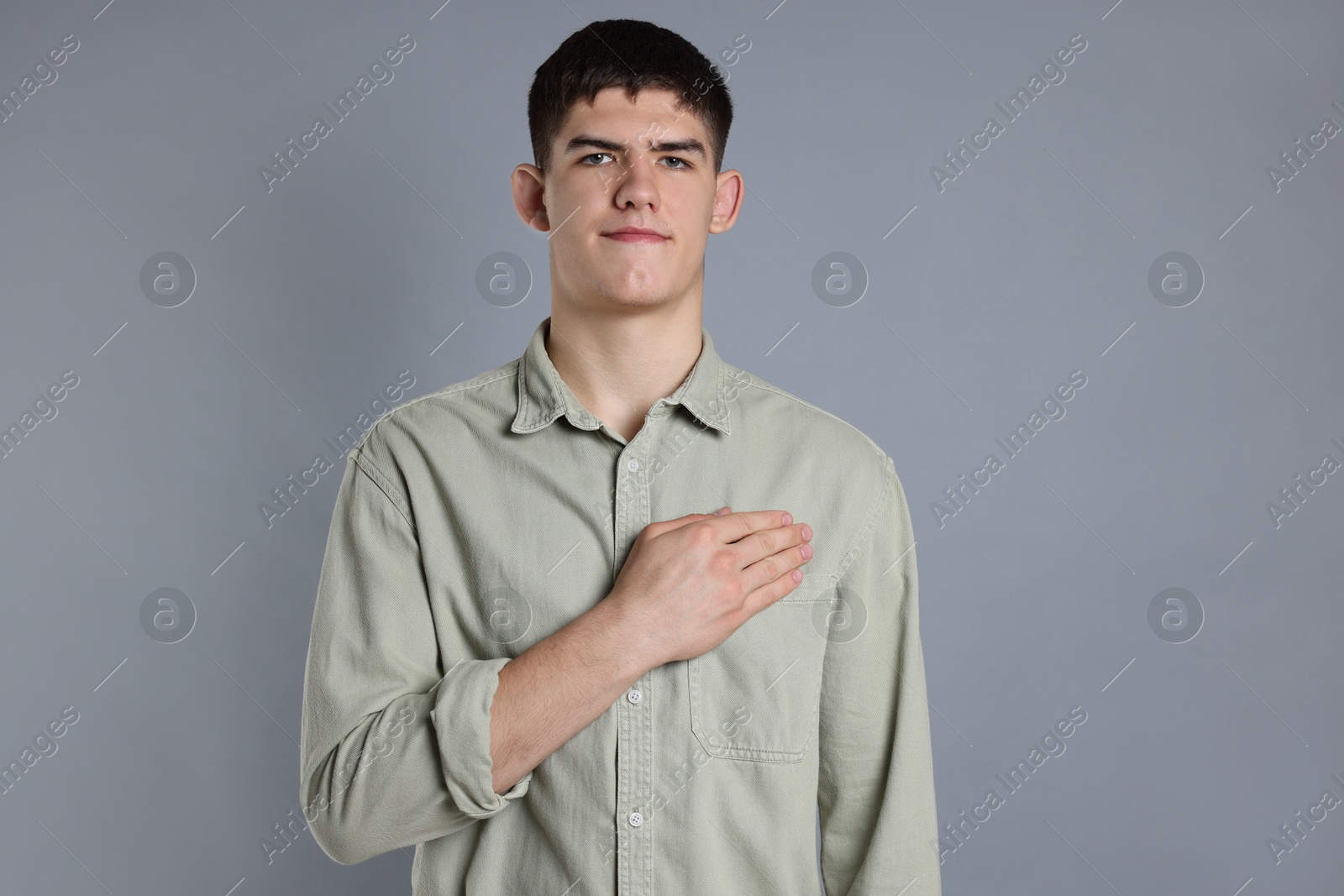 Photo of Man showing oath gesture on grey background