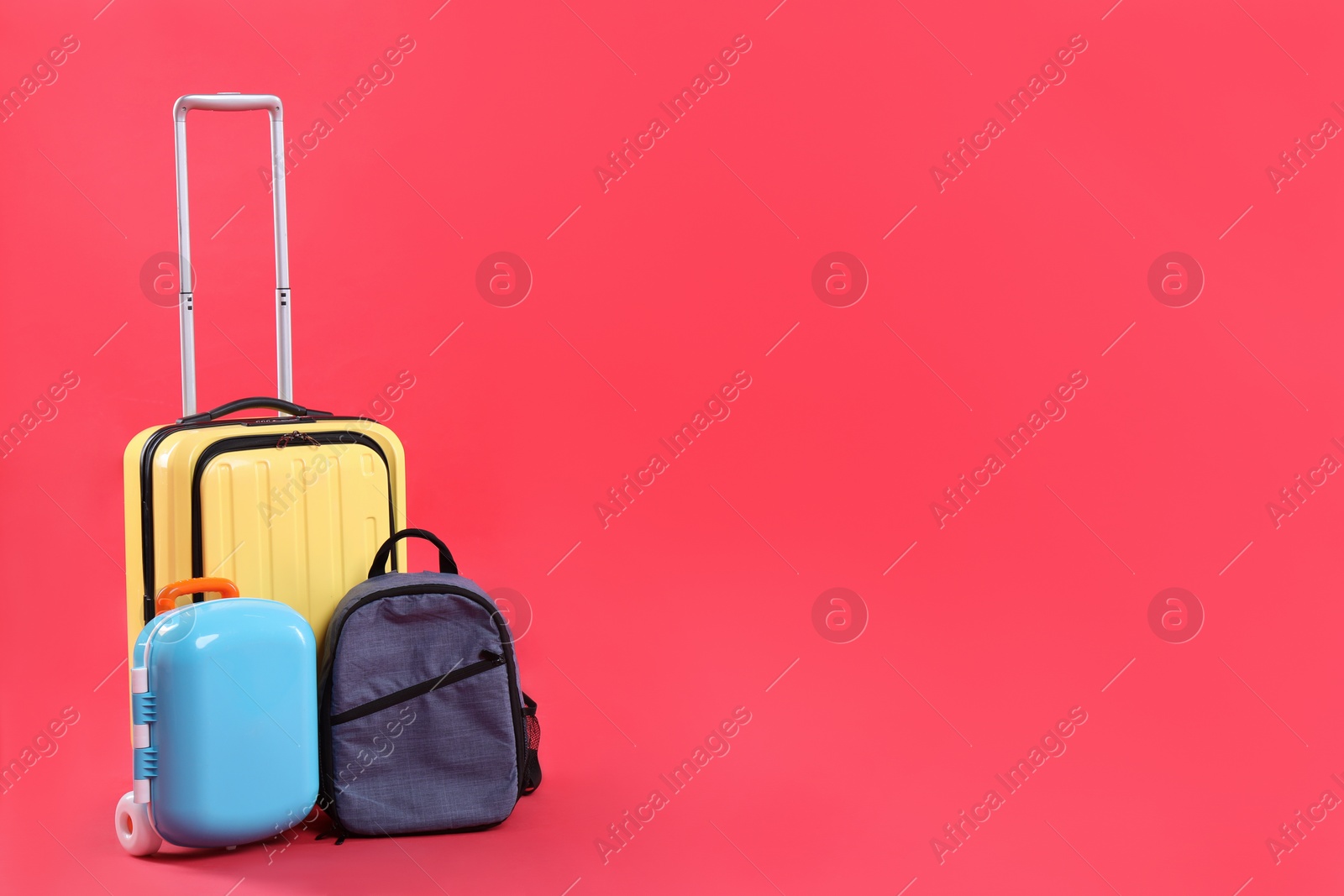 Photo of Travel abroad. Suitcases and backpack on red background. Space for text