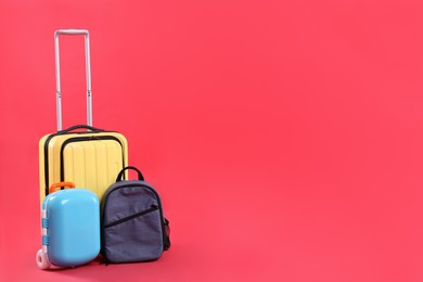 Photo of Travel abroad. Suitcases and backpack on red background. Space for text