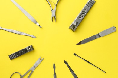 Photo of Frame of pedicure tools on yellow background, flat lay. Space for text