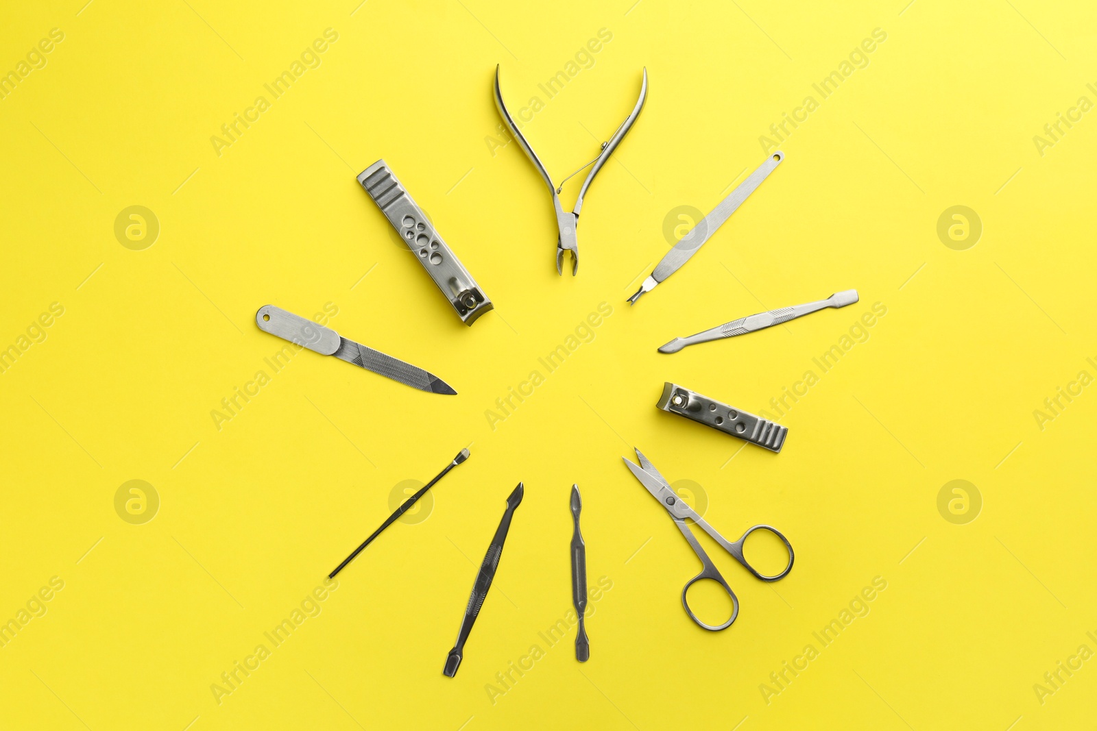 Photo of Set of pedicure tools on yellow background, flat lay