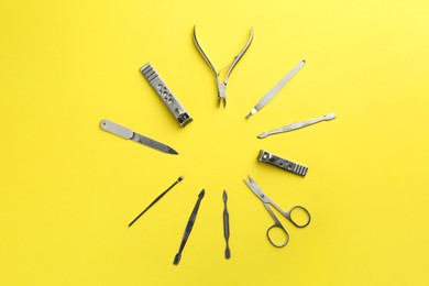 Photo of Set of pedicure tools on yellow background, flat lay