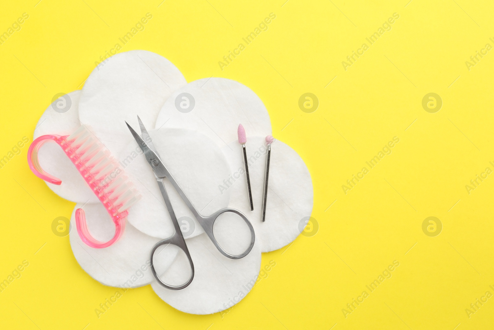 Photo of Set of pedicure tools on yellow background, flat lay. Space for text