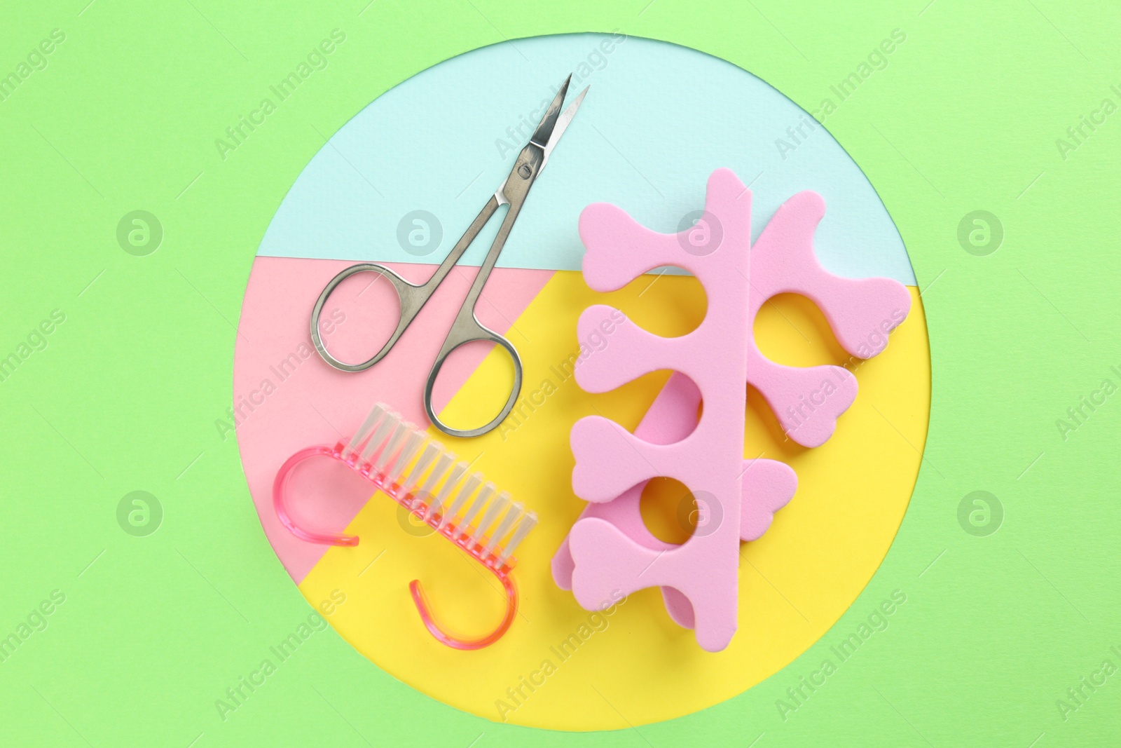 Photo of Set of pedicure tools on color background, flat lay