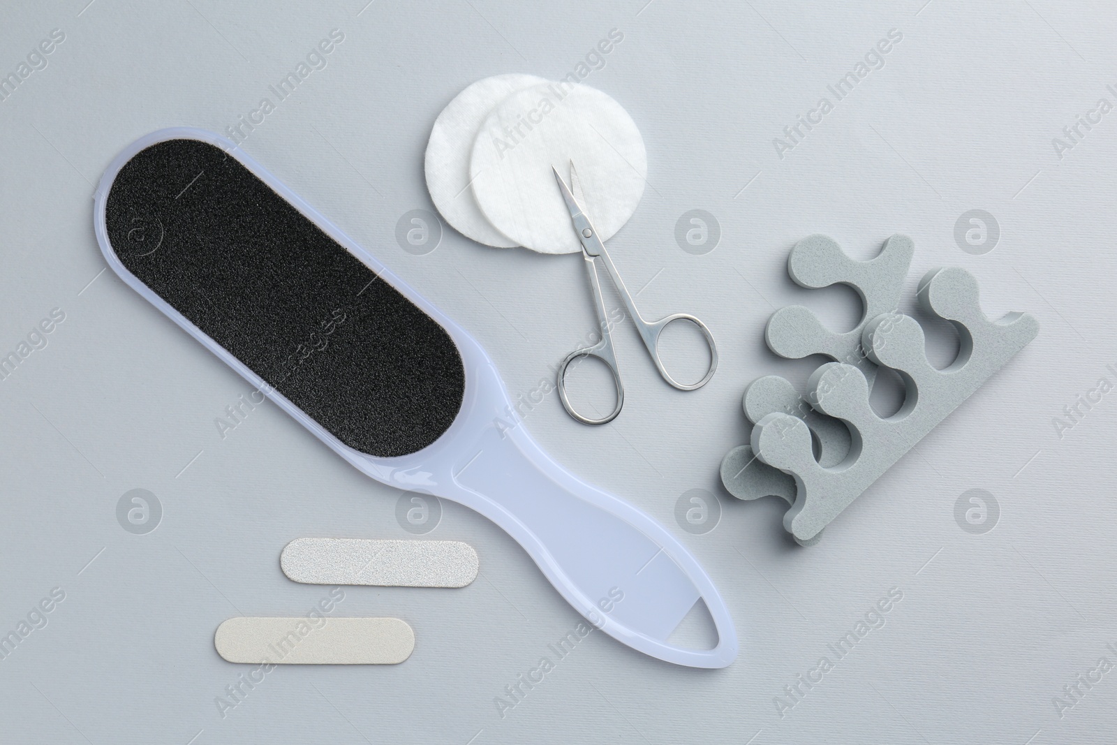 Photo of Set of pedicure tools on light grey background, flat lay