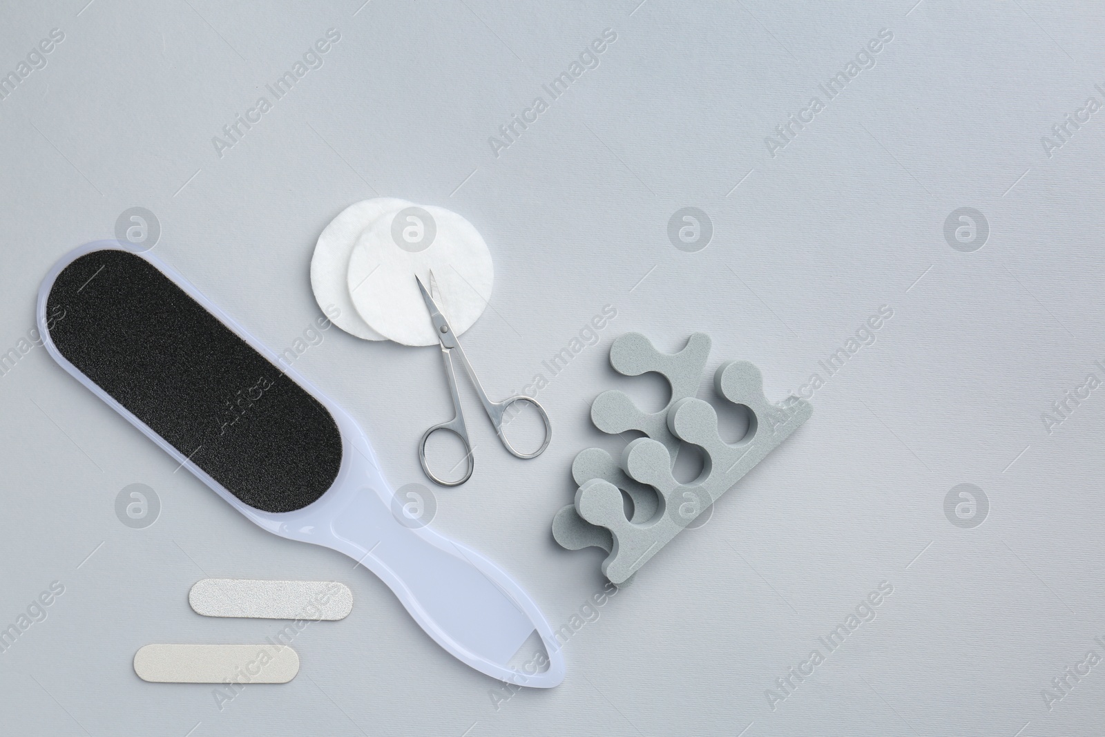 Photo of Set of pedicure tools on light grey background, flat lay. Space for text