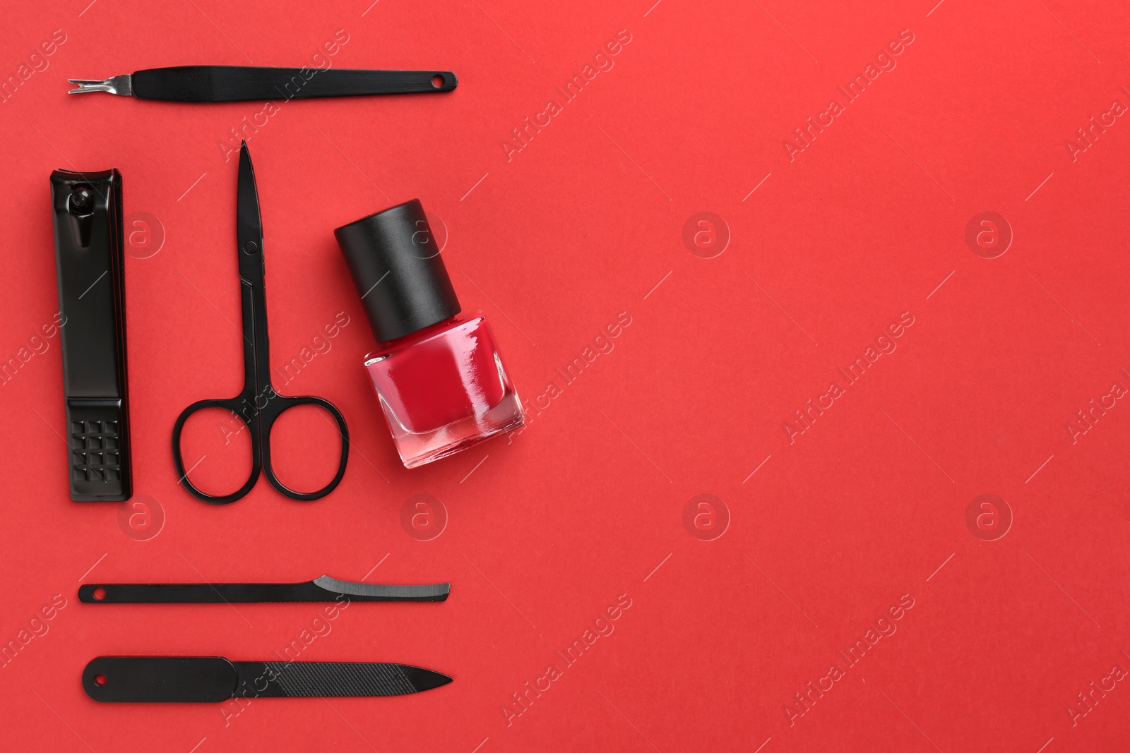 Photo of Set of pedicure tools on red background, flat lay. Space for text