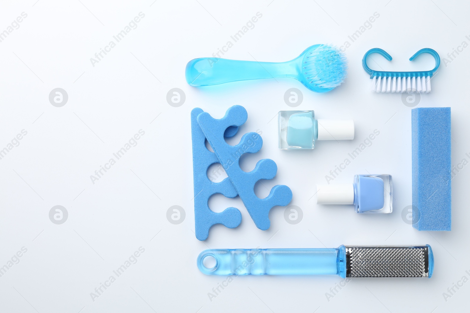 Photo of Set of pedicure tools on light background, flat lay. Space for text