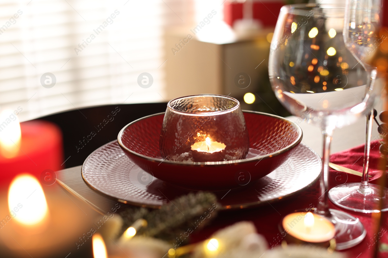 Photo of Christmas place setting with festive decor on table in room, closeup