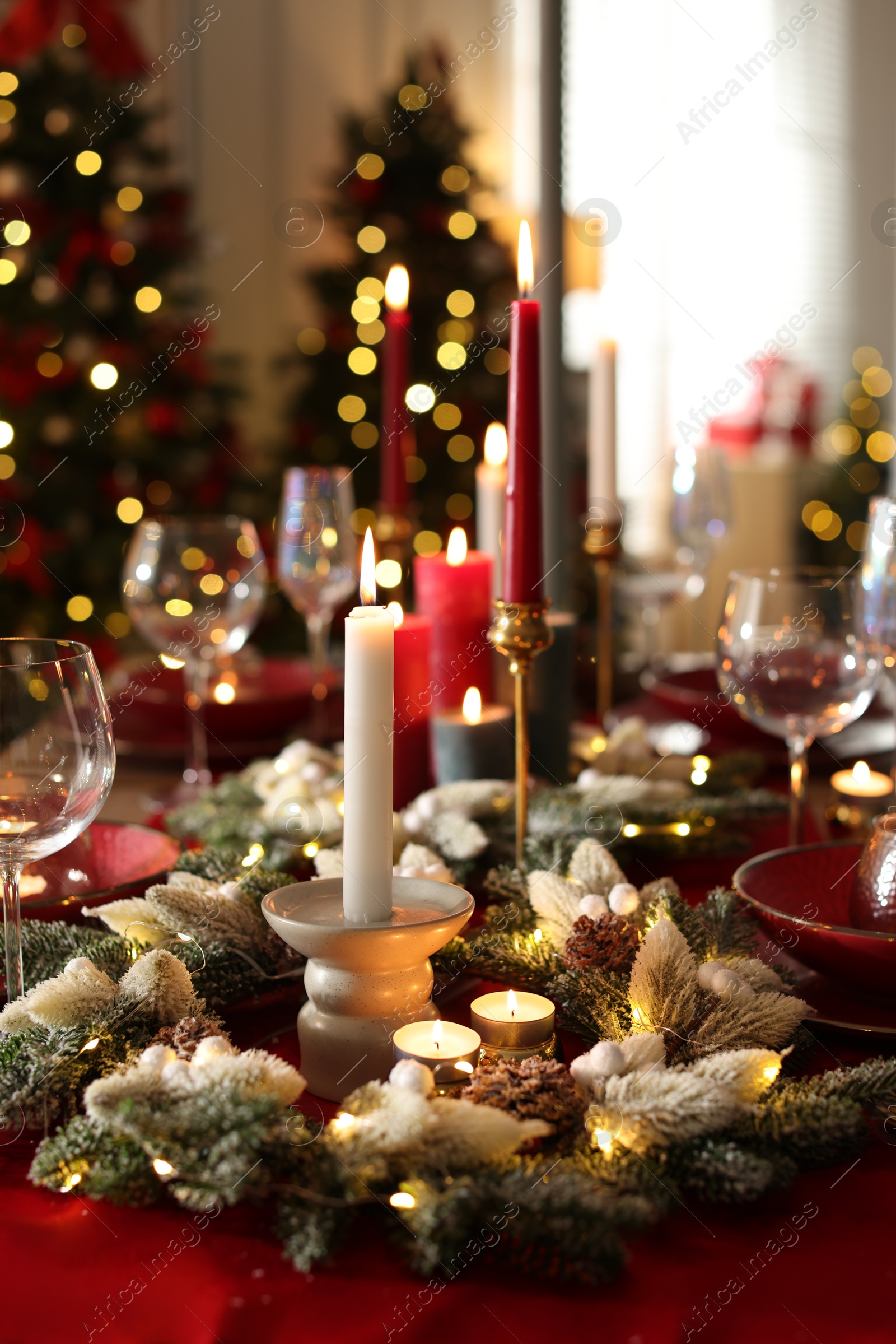 Photo of Christmas place setting with festive decor on table in room, closeup