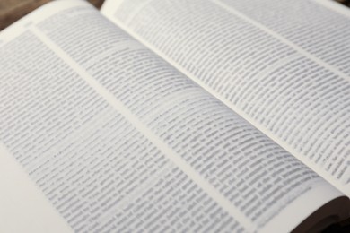 Open Holy Bible in English language on table, closeup