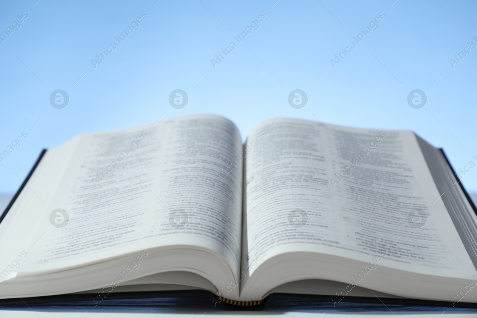 Photo of Open Holy Bible in English language on table, closeup. Space for text