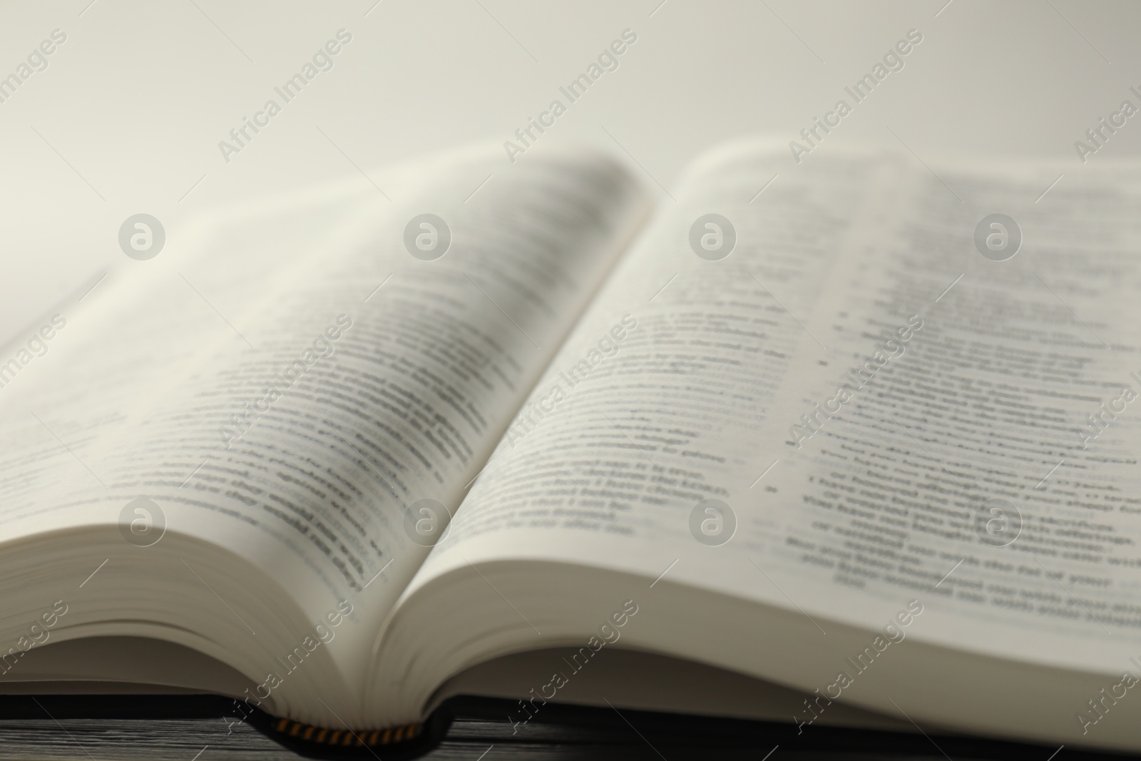 Photo of Open Holy Bible in English language on table, closeup