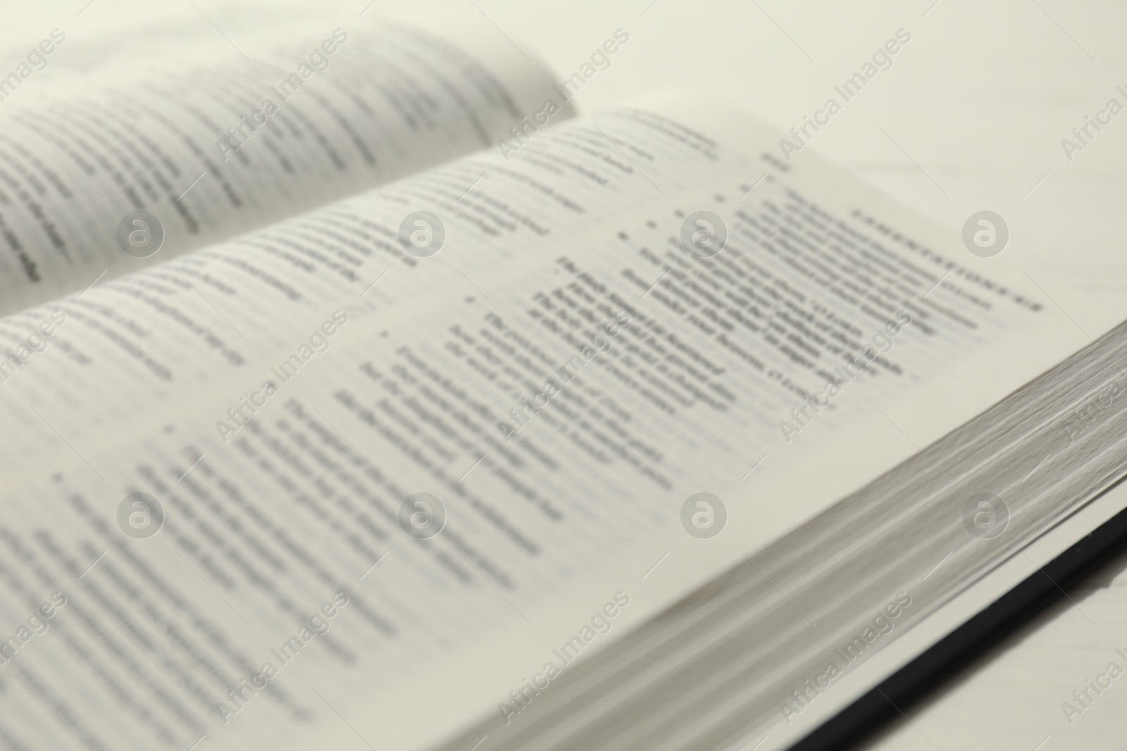 Photo of Open Holy Bible in English language on table, closeup