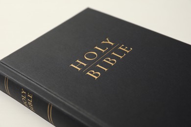 Photo of Hardcover Holy Bible on white table, closeup