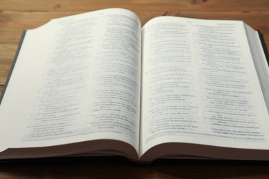 Open Holy Bible in English language on wooden table, closeup