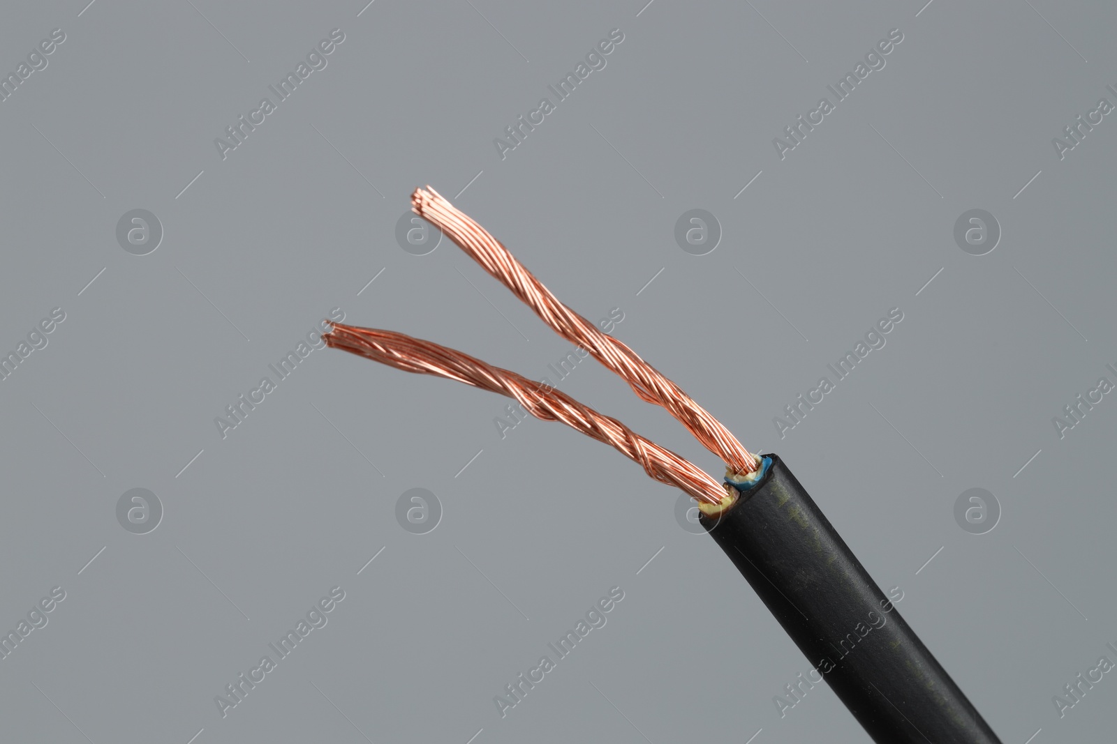 Photo of Black stripped electrical wire on light grey background, closeup