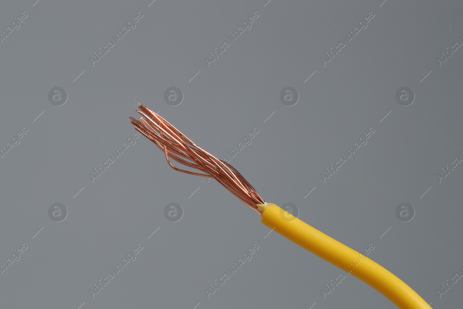 Photo of Yellow stripped electrical wire on light grey background, closeup