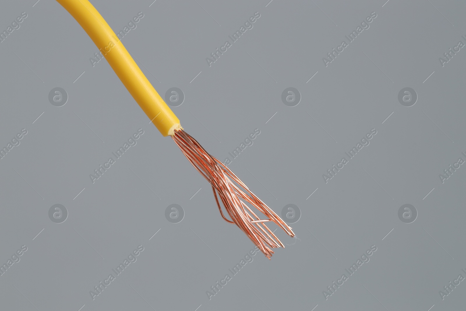 Photo of Yellow stripped electrical wire on light grey background, closeup