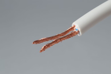 Photo of White stripped electrical wire on light grey background, closeup