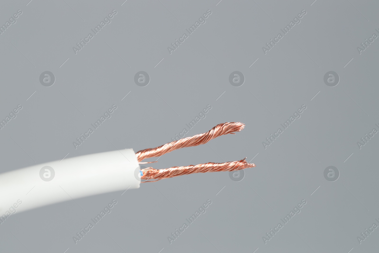 Photo of White stripped electrical wire on light grey background, closeup