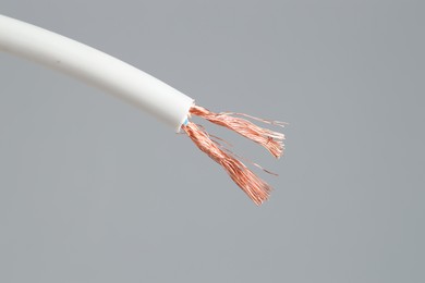 Photo of White stripped electrical wire on light grey background, closeup