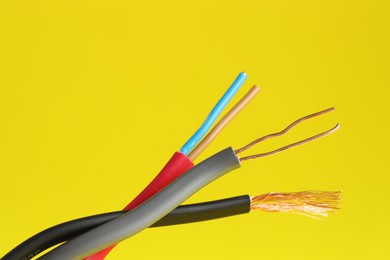 Photo of Many stripped electrical wires on yellow background, closeup