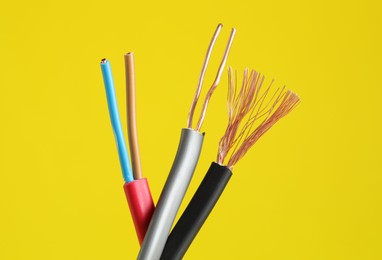 Photo of Many stripped electrical wires on yellow background, closeup