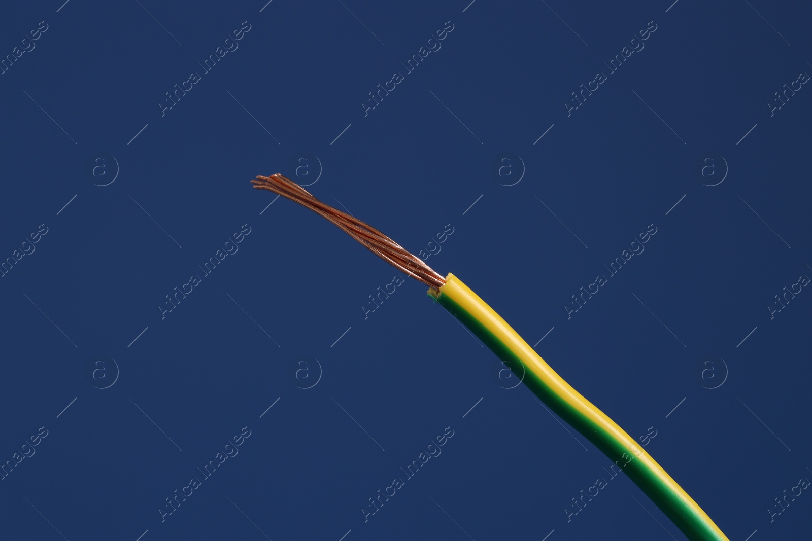 Photo of Stripped electrical wire on blue background, closeup