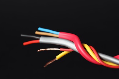 Photo of Many stripped electrical wires on black background, closeup