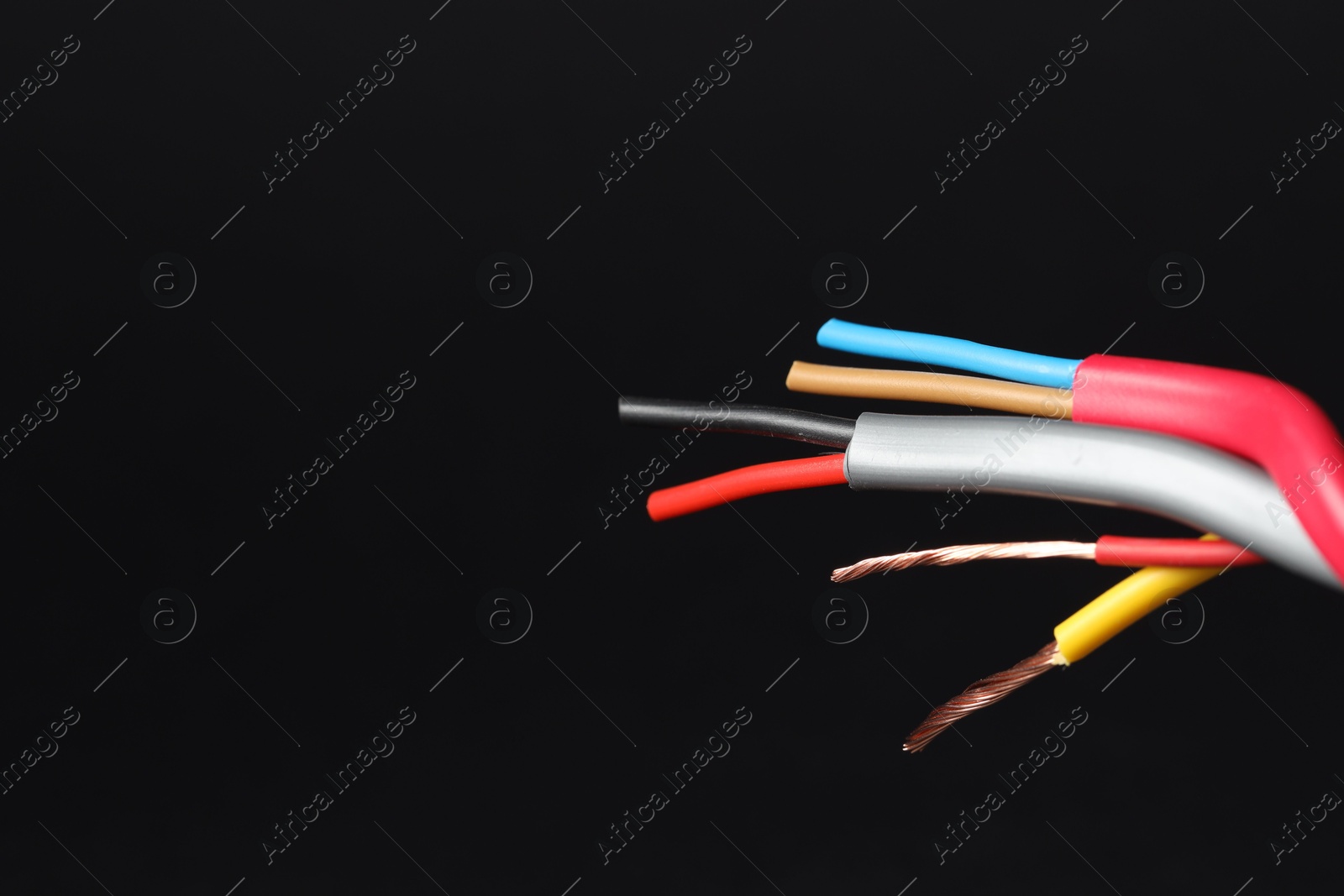 Photo of Many stripped electrical wires on black background, closeup. Space for text