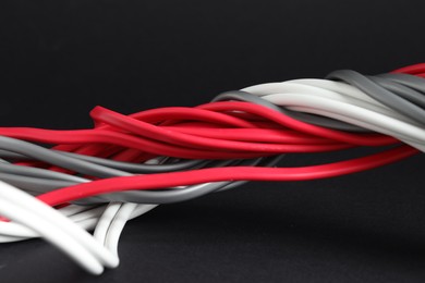 Photo of Many electrical wires on black background, closeup