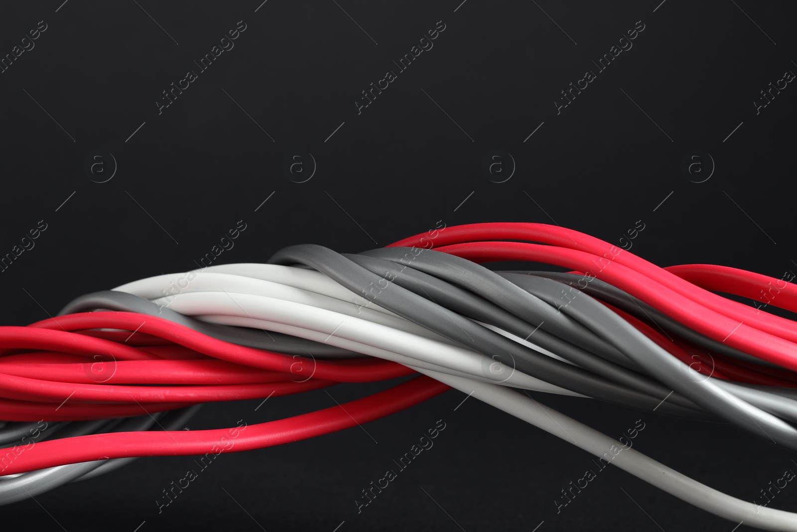 Photo of Many electrical wires on black background, closeup