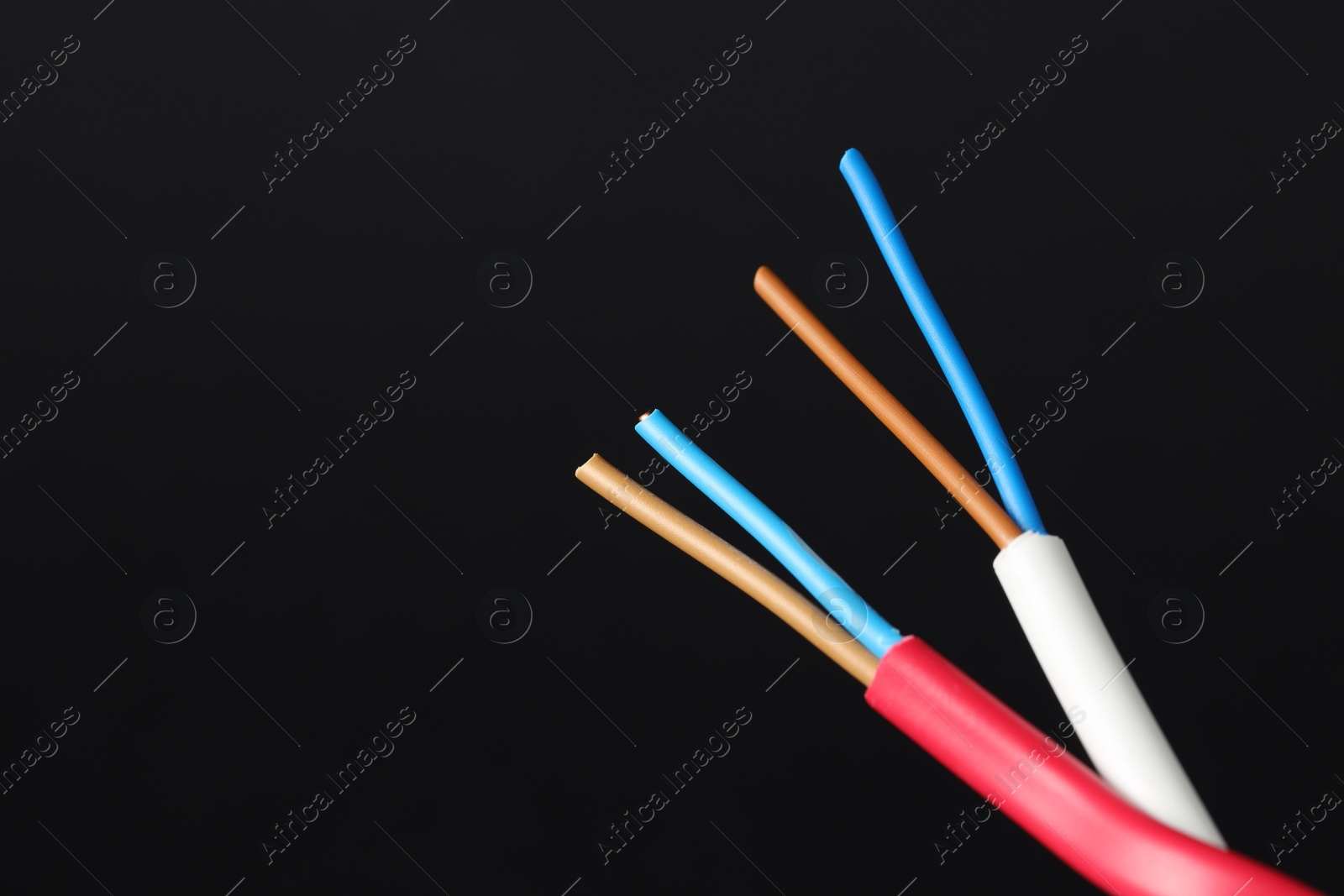 Photo of Stripped electrical wire on black background, closeup. Space for text