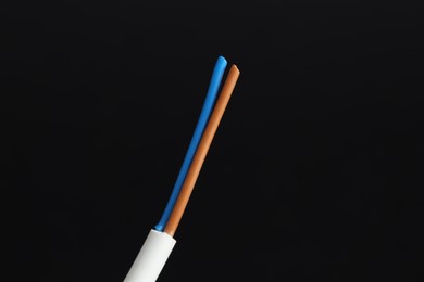 Photo of White stripped electrical wire on black background, closeup