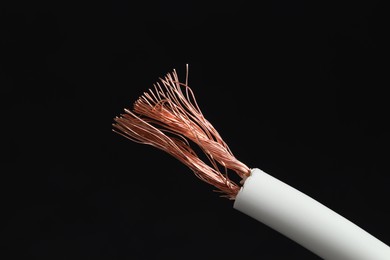 Photo of White stripped electrical wire on black background, closeup