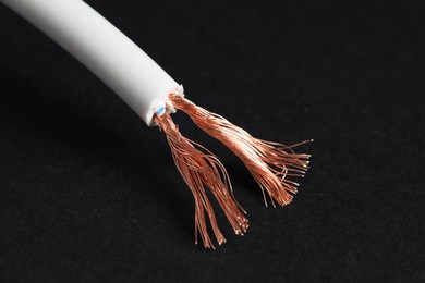 Photo of White stripped electrical wire on black background, closeup