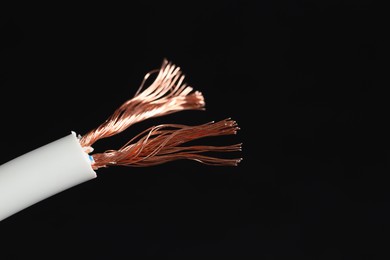 Photo of White stripped electrical wire on black background, closeup